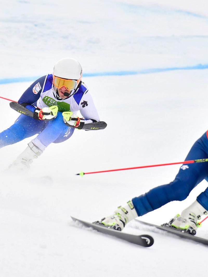 male vision impaired Para alpine skier Jon Santacana Maiztegui skies through a gate following his guide skier
