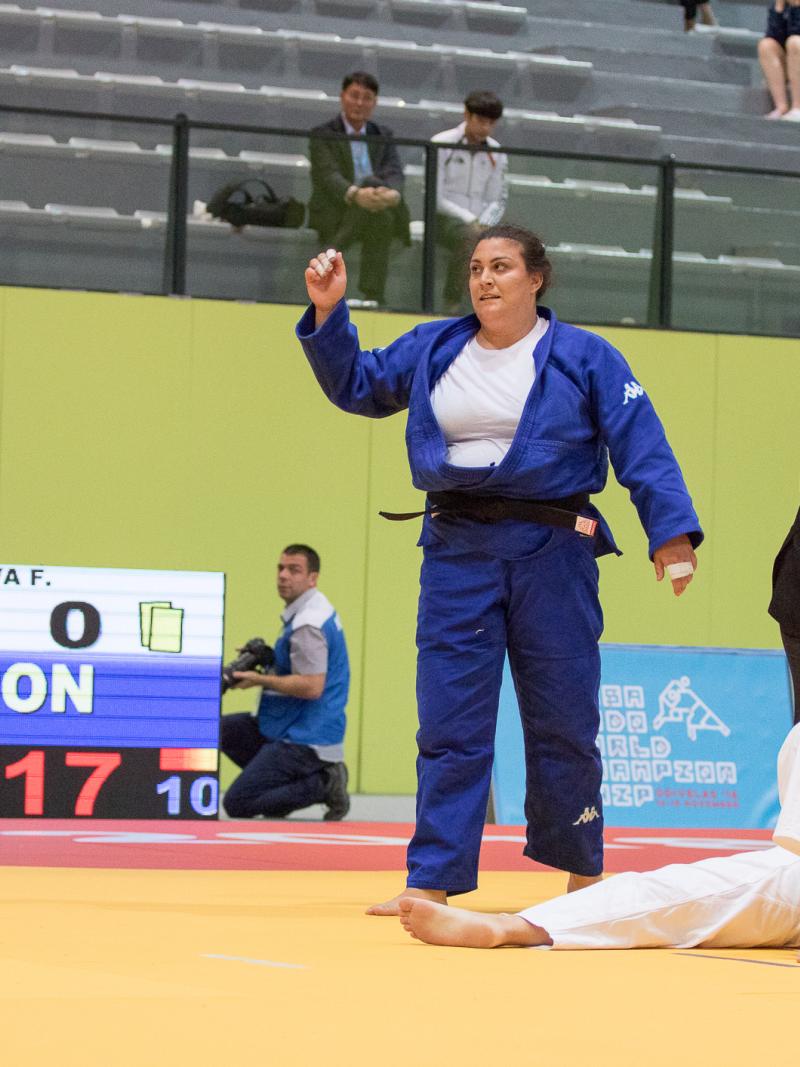 female judoka Carolina Costa stands over her opponent on the ground after winning the fight by ippon