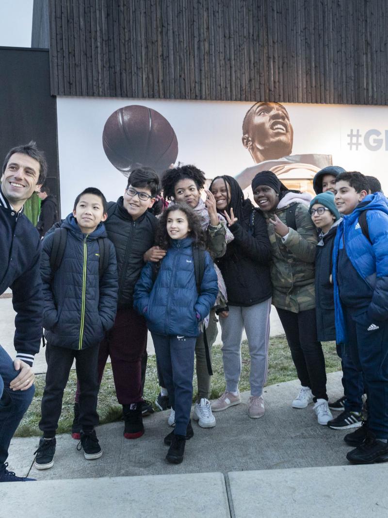 Tony Estanguet takes a selfie with some schoolchildren outside a school in Paris