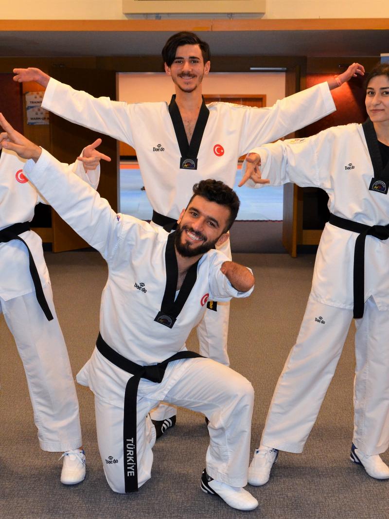 a group of Turkish taekwondo fighters posing for the camera