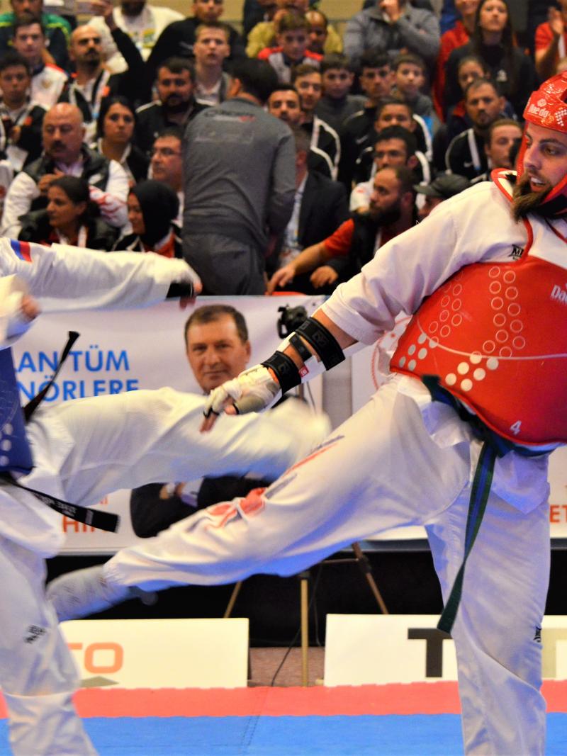 male Para taekwondo fighter Matt Bush kicks another fighter around the legs