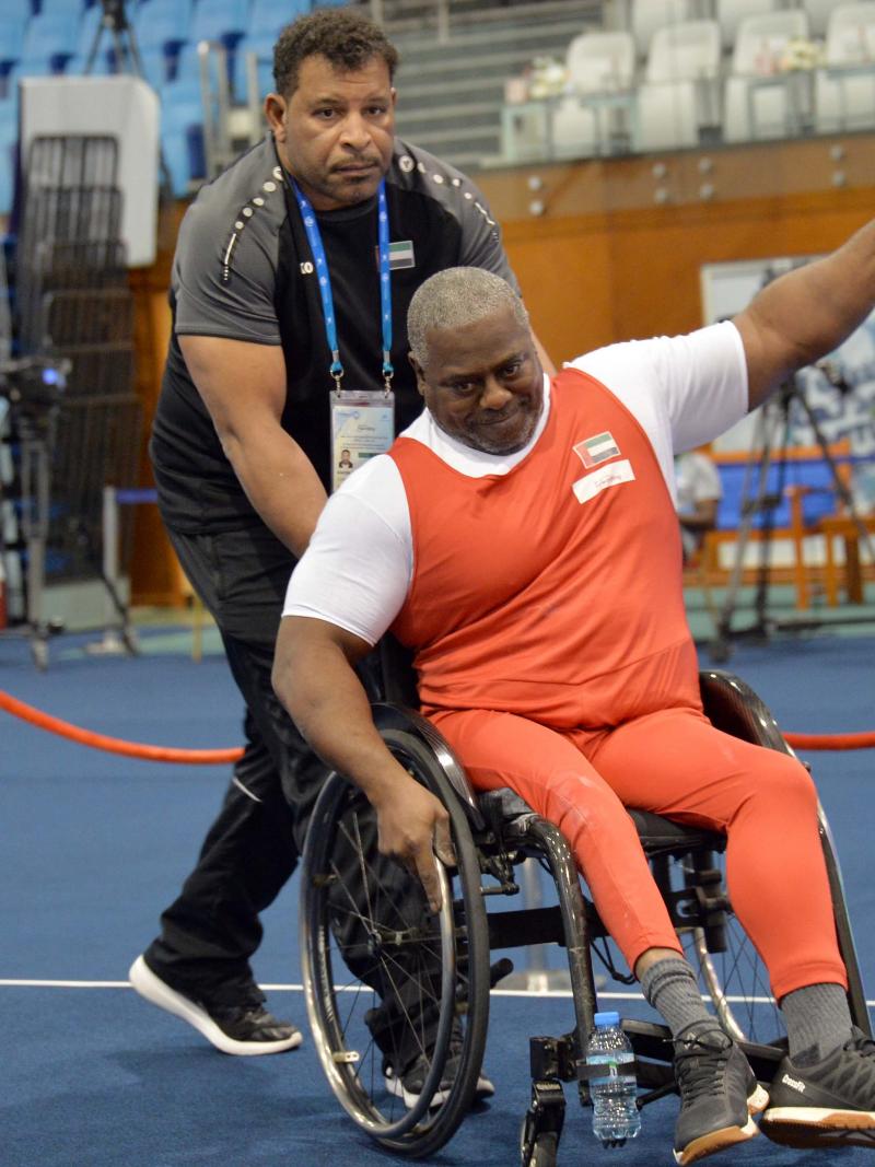 male Para powerlifter Mohammed Khamis Khalaf gives a thumbs up and smiles