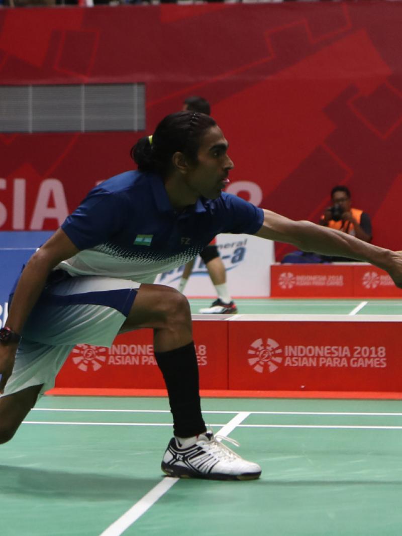 male Para badminton player Pramod Bhagat lunges to play a backhand