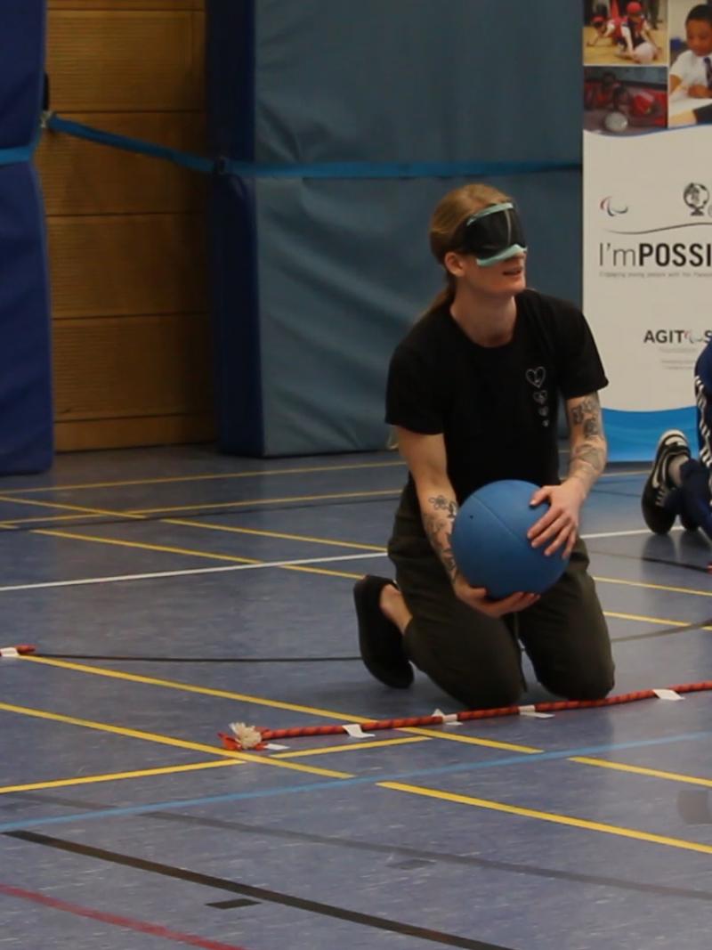 teachers with eyeshades play goalball in sport hall of the Bonn International School