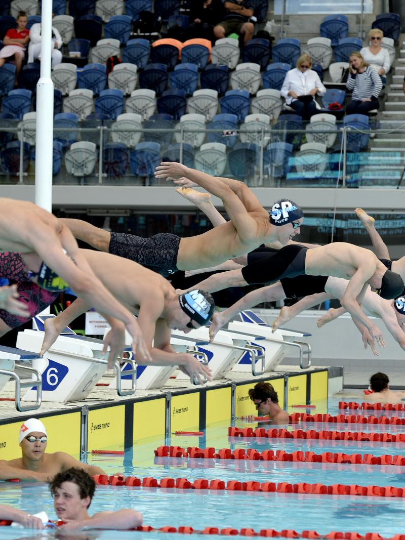 male Para swimmers diving into a pool at the start of the race in Melbourne