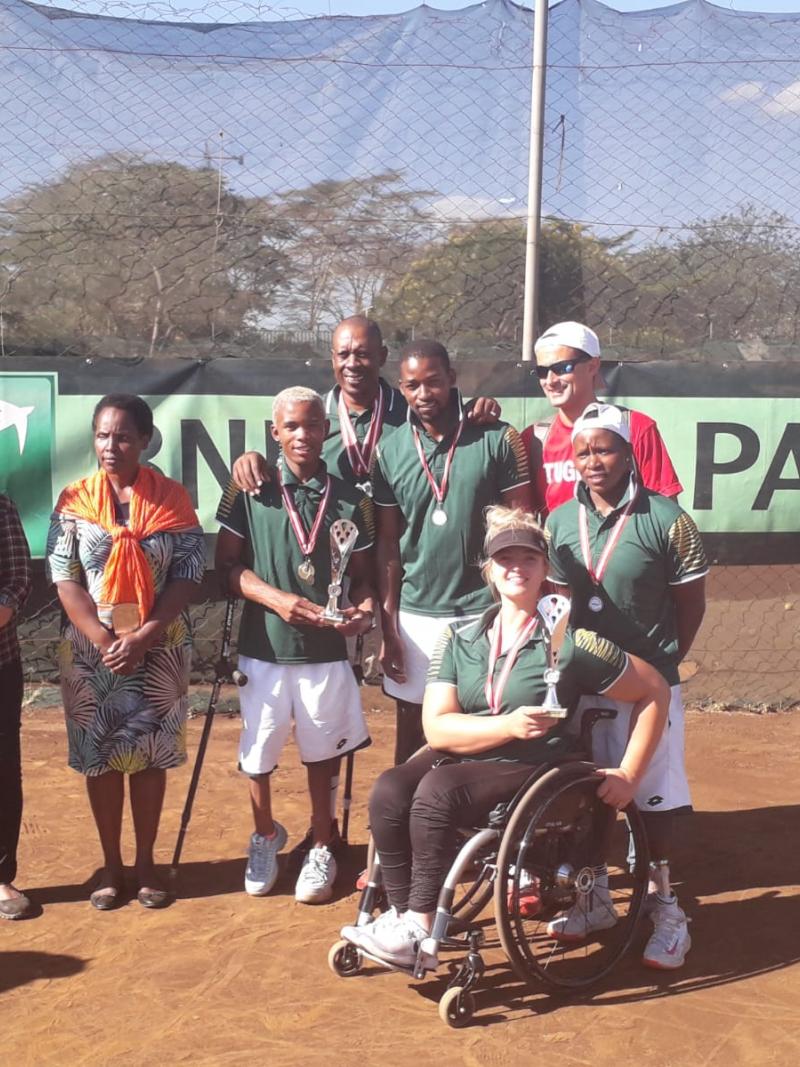 male and female wheelchair tennis players from South Africa hold up a trophy and smile