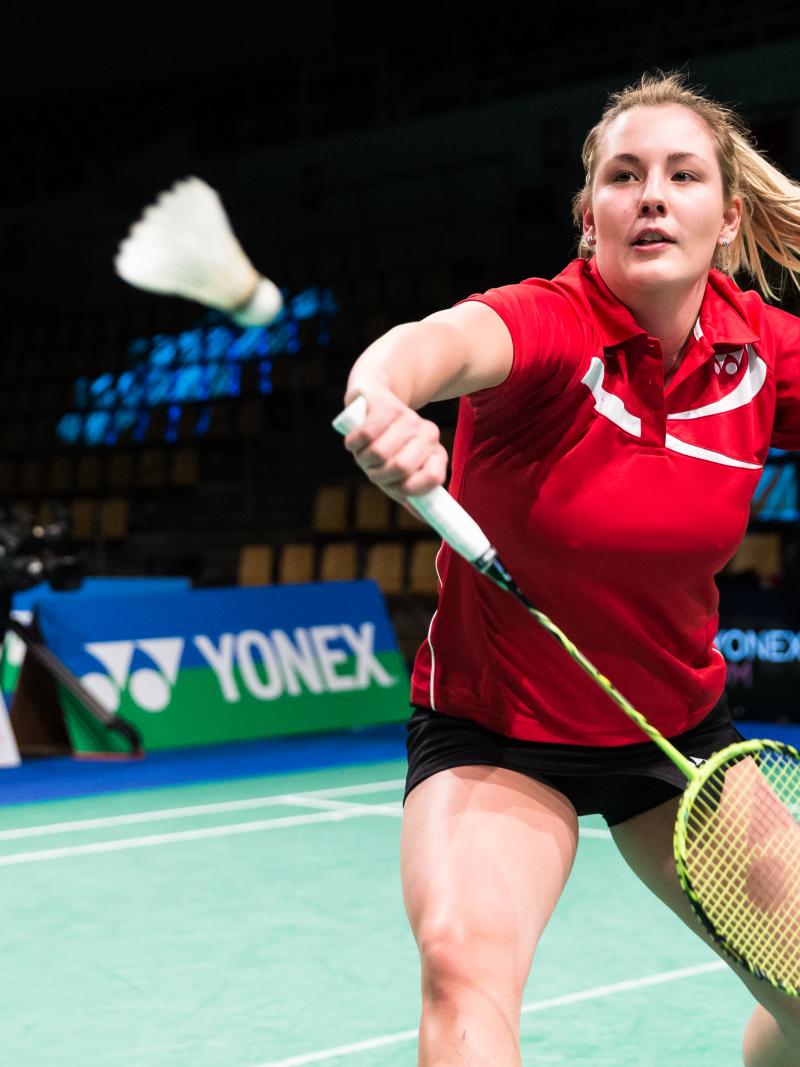 female Para badminton player Cathrine Rosengren reaches to play a backhand