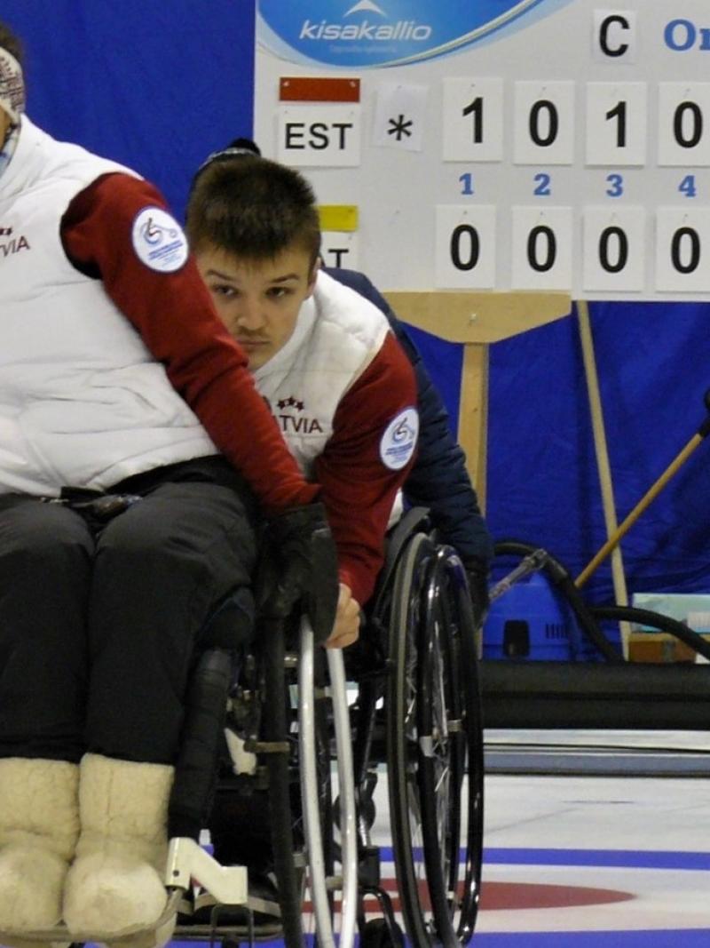 female wheelchair curler Polina Rozkova plays a stone