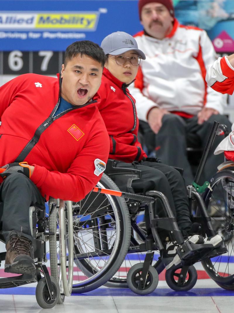 Chinese male wheelchair curler reacts as he releases his stone
