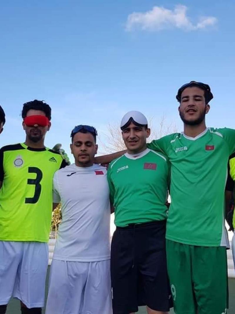 a group of five blind footballers from Oman smiling down at the camera