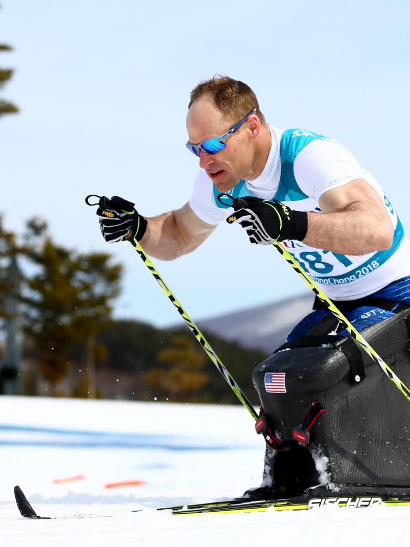 male Para Nordic sit skier Daniel Cnossen pushes through the snow