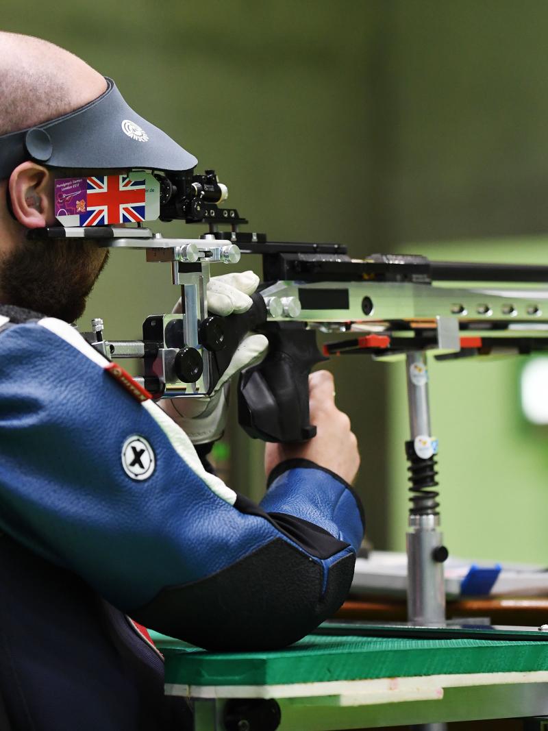 male Para shooter Ryan Cockbill prepares to shoot a rifle