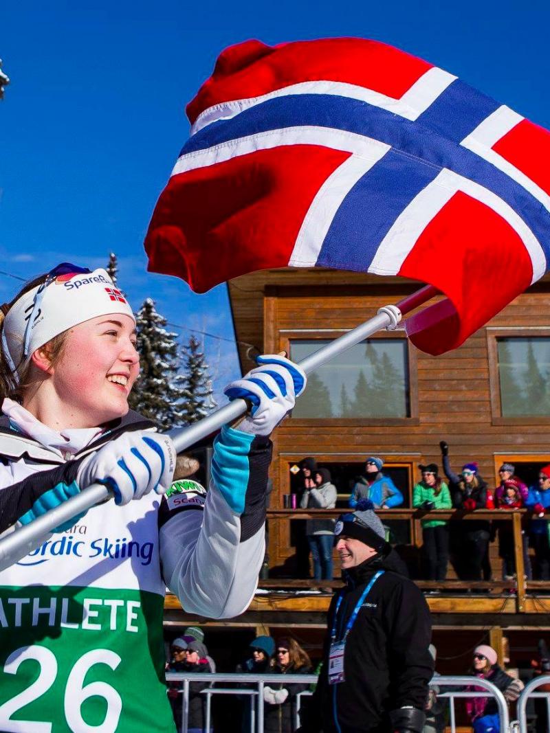 female Para Nordic skier Vilde Nilsen holds up a Norwegian flag