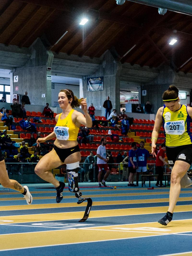 three female single amputee sprinters crossing the finish line