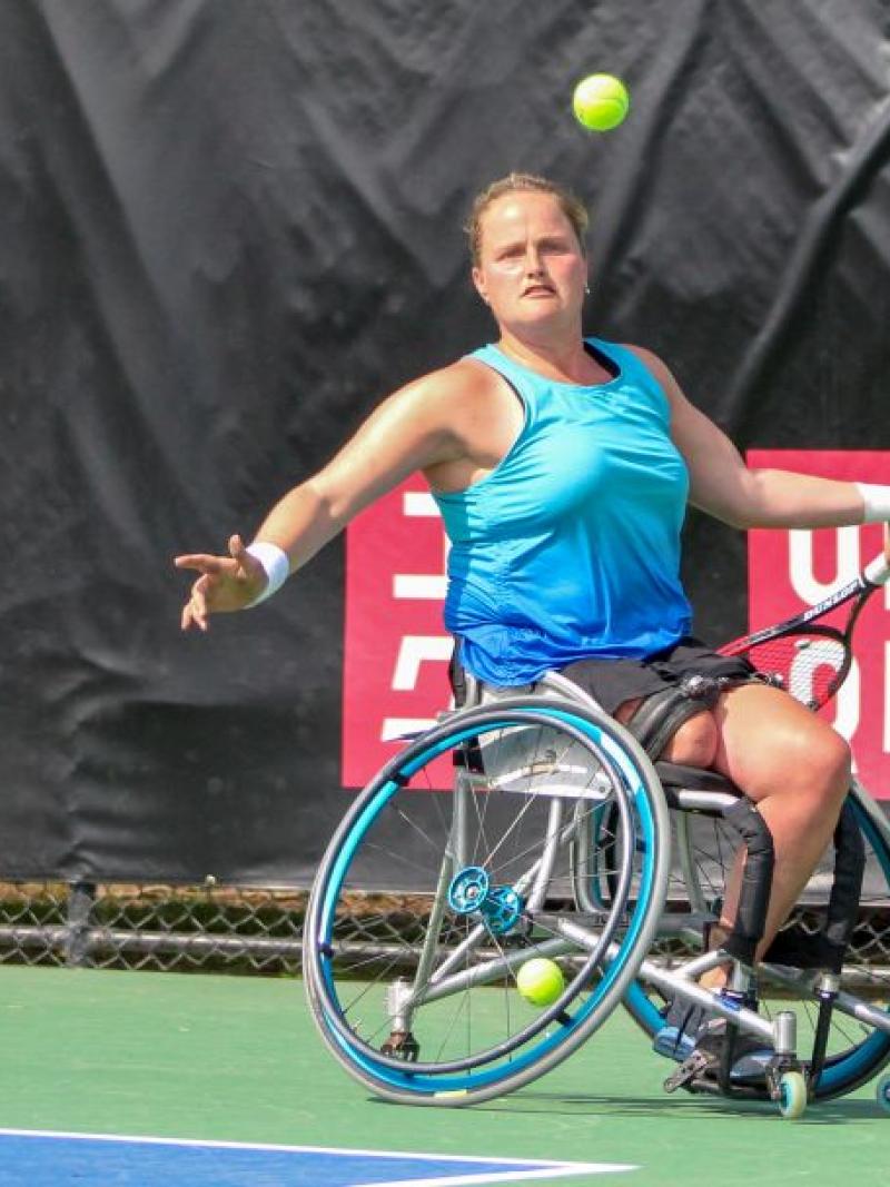 female wheelchair tennis player Aniek van Koot plays a backhand on a hard court
