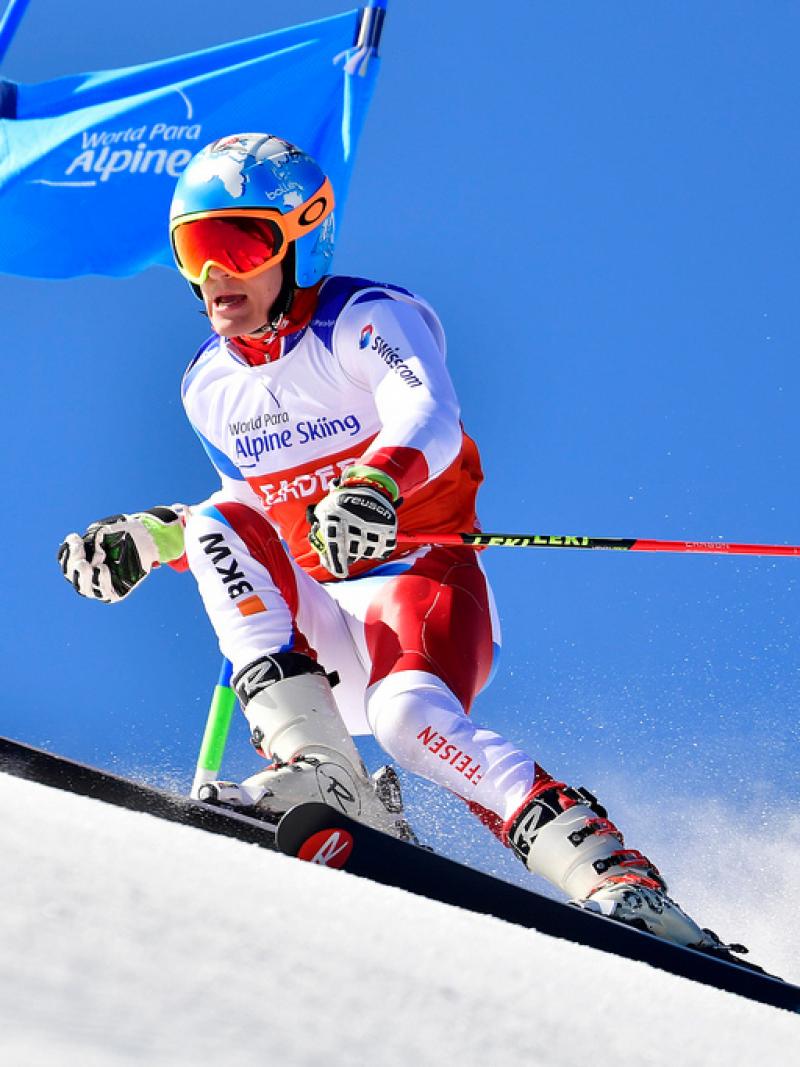 male Para alpine standing skier Theo Gmur skies through a gate