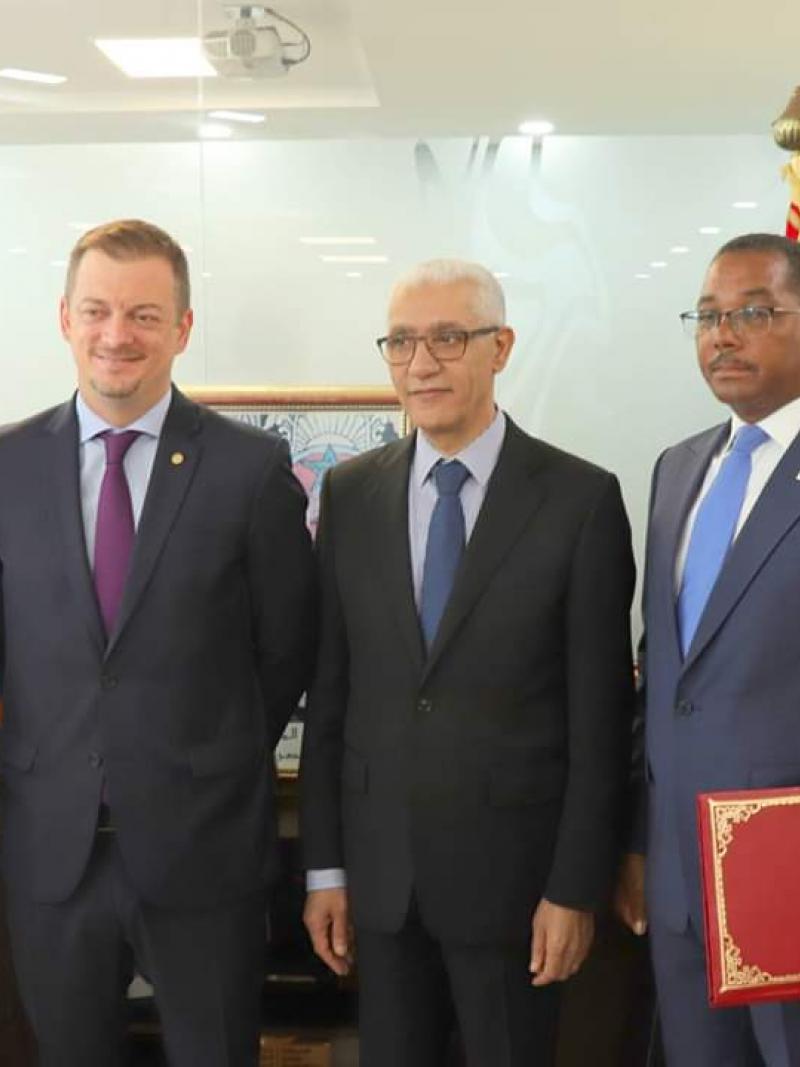six men including IPC President Andrew Parsons standing side by side in an office
