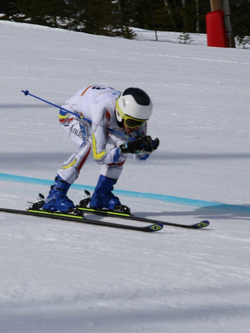 male Para alpine standing skier Roger Puig Davi crouches down as he crosses the finish line