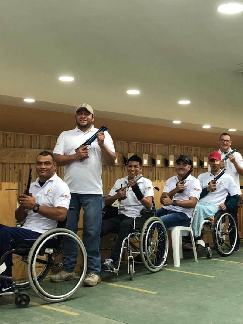 a group of male and female Para shooters from Colombia next to the target range