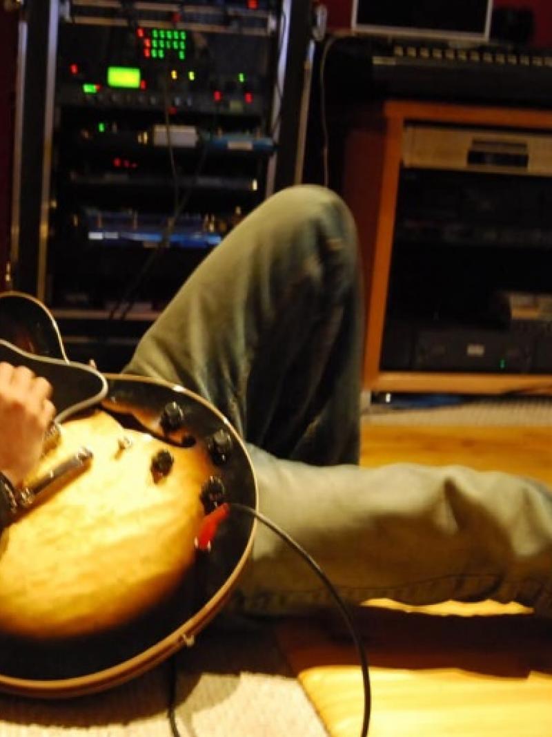 Man playing guitar while lying down