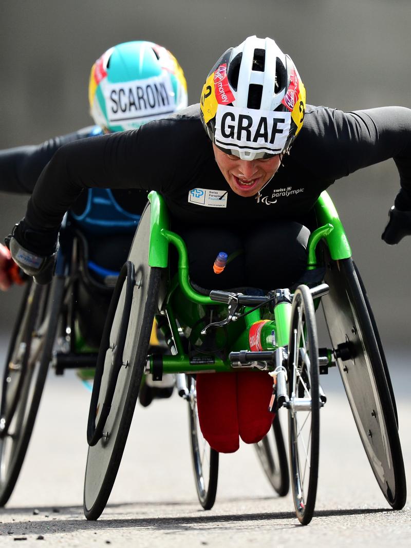 female wheelchair racer Sandra Graf leading another athlete duringa road race