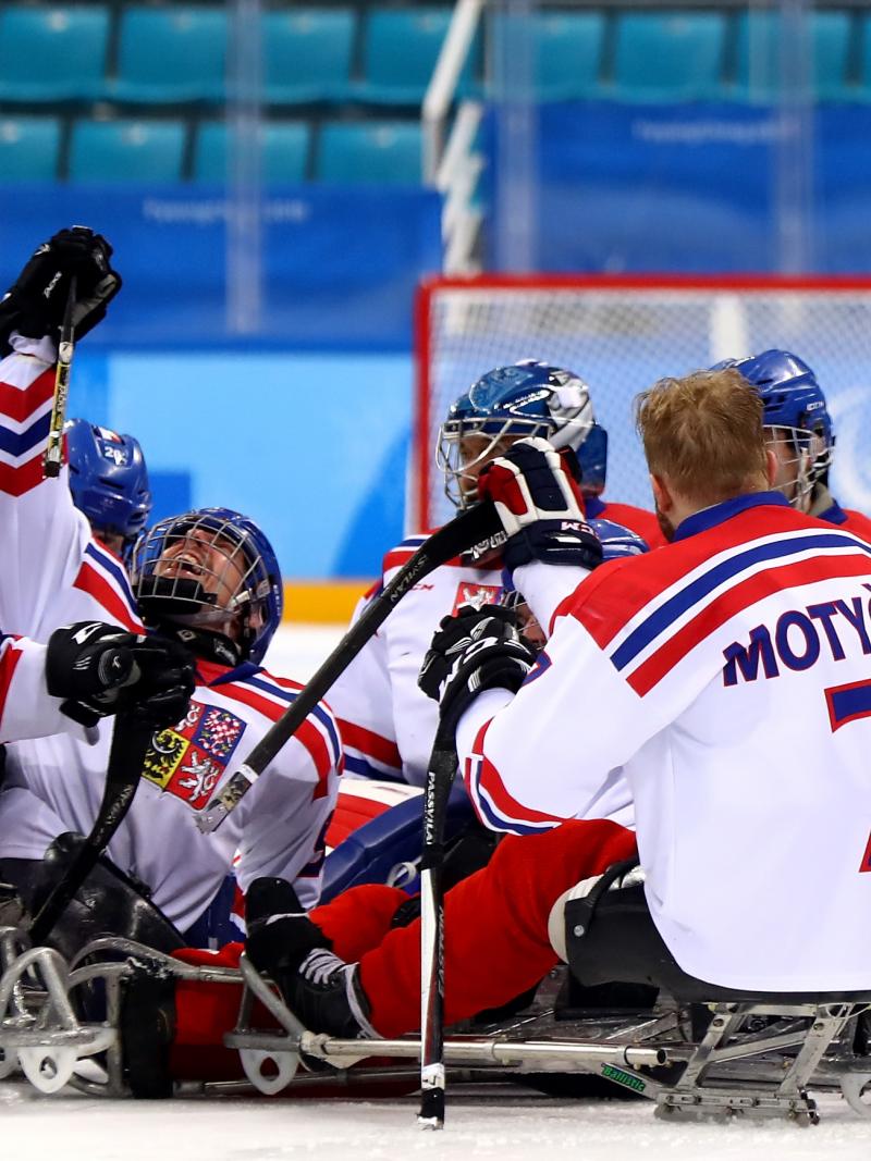 male Para ice hockey players from Czech Republic celebrating and hugging on the ice