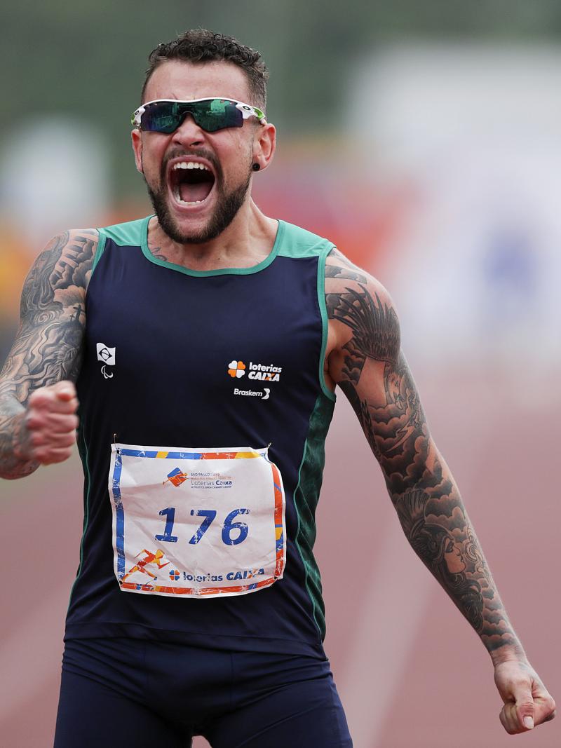 male Para athlete Vincent Rodrigues yells out as he crosses the finish line to win the race