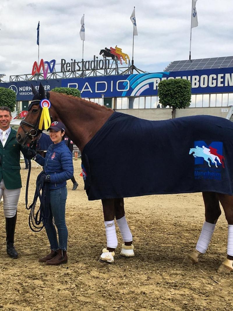 Brazilian Para dressage rider posing with his horse and a staff member for a photo