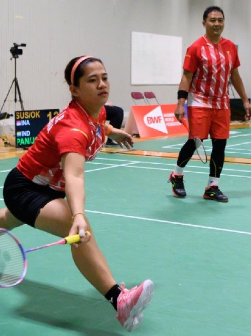 Indonesian female badminton player lunges for the birdie