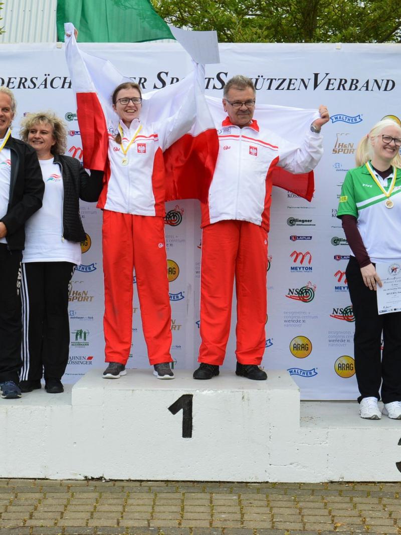 Three vision impaired shooting Para sport athletes on the podium with their guides