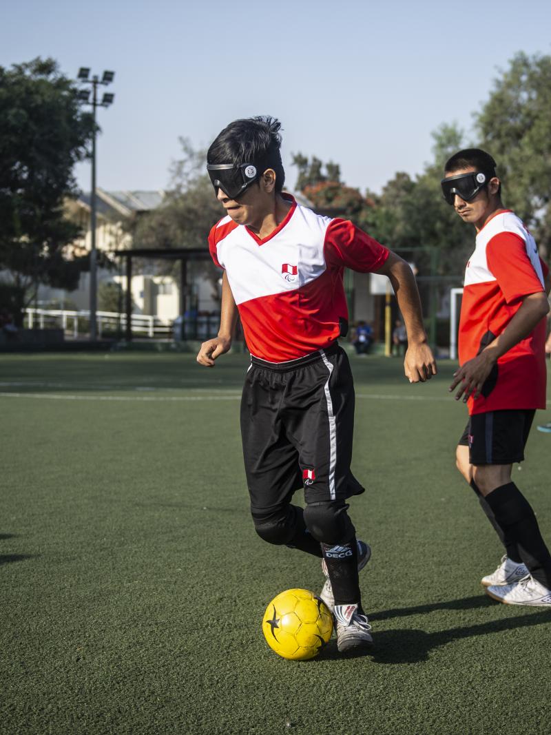 Blind football player wearing Peruvian shirt in posession of the ball