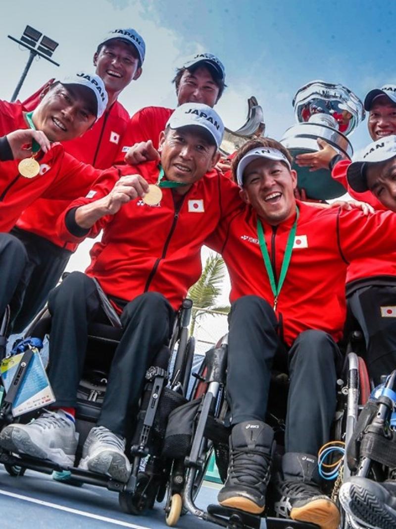 Japanese quad team smile and show their gold medal to the camera