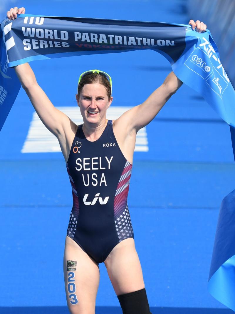 Female triathlete with left leg amputation celebrates as she crosses the finish line
