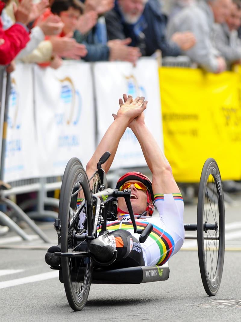 Dutch Para cyclist Jetze Plat celebrates with his hands up while crossing the finish line