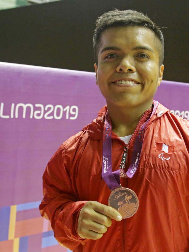 Diego Quispe smiles while he holds the bronze medal he won at the Lima World Cup