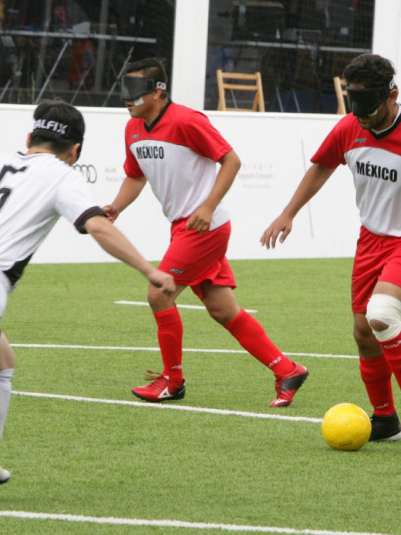 Mexican blind football player Jorge Lanzagorta controls the ball and faces South Korean defender