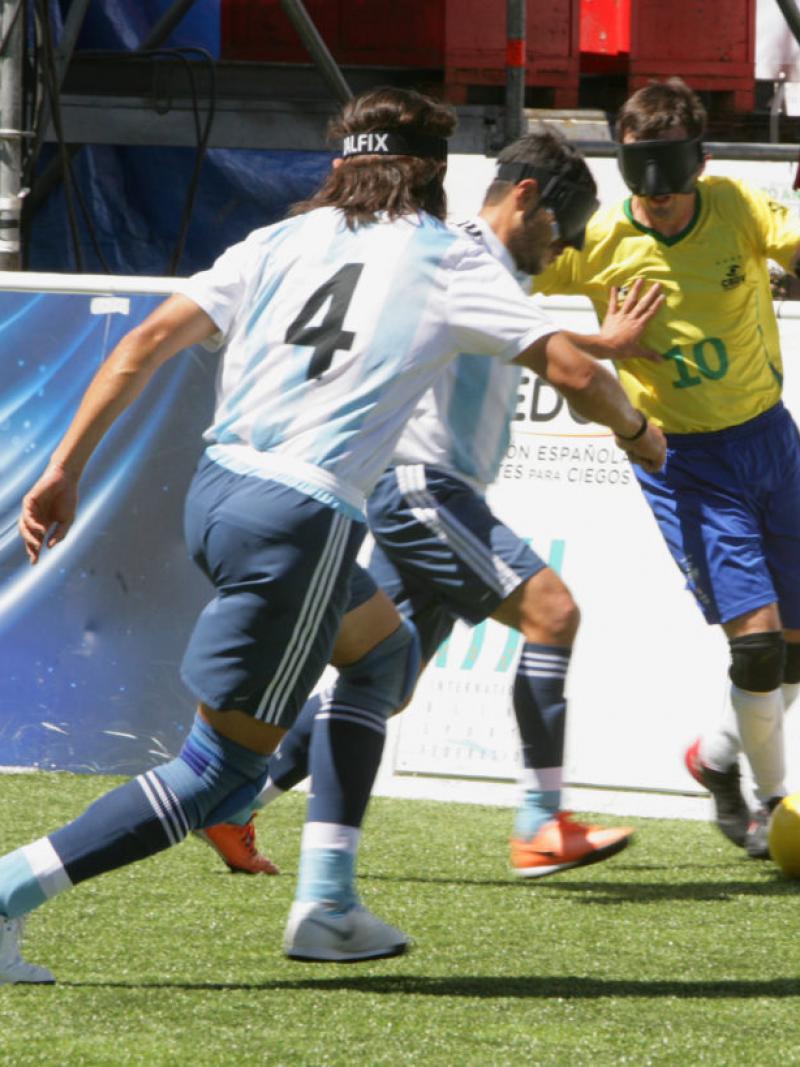 Ricardinho takes the ball while facing two Argentinian defenders