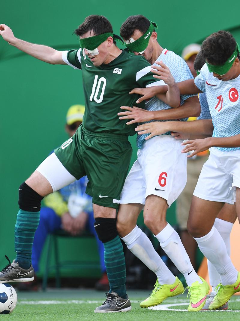 Ricardinho controls the ball, while two Turkish players try to take it from him