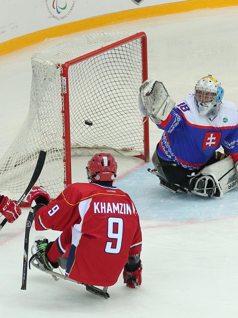 Two Russian Para ice hockey players in front the Slovakian goaltender