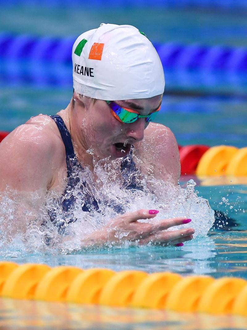 A female swimmer with a cap showing the flag of Ireland
