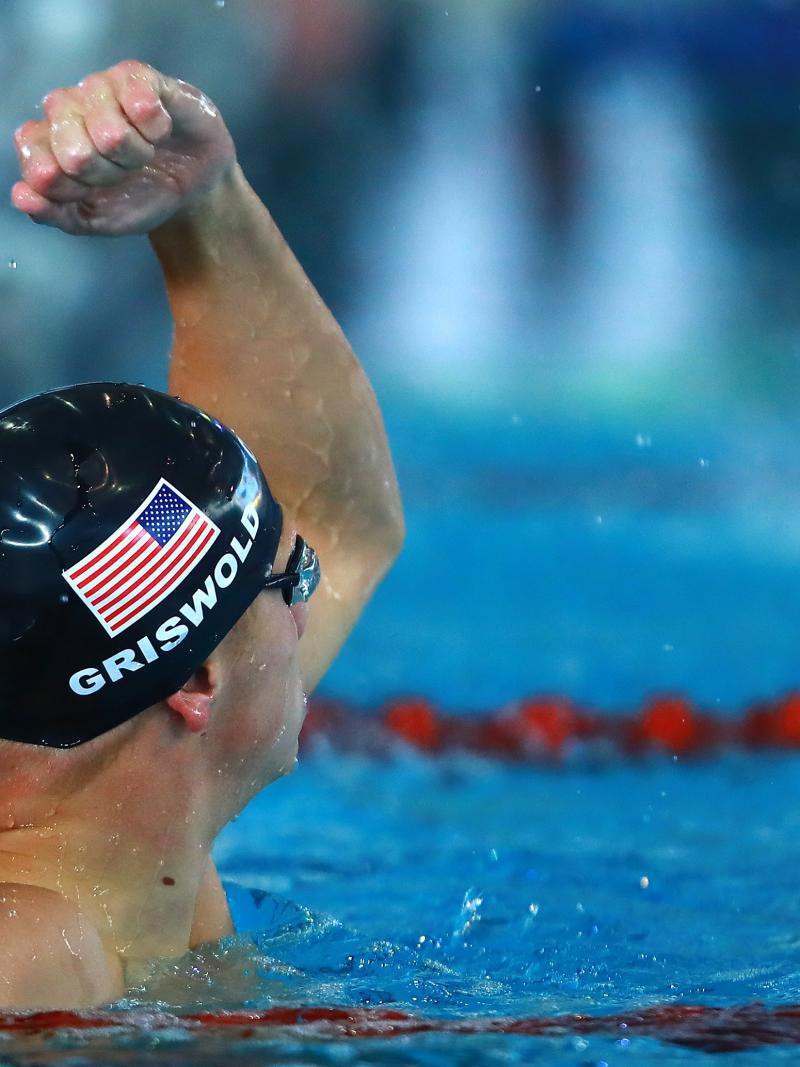 male Para swimmer Robert Griswold punches the air in the pool after winning a race