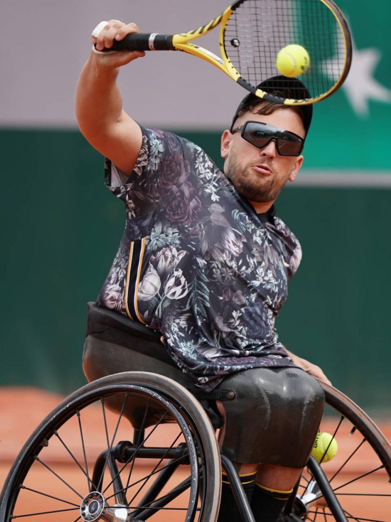 male wheelchair tennis player Dylan Alcott hits a backhand on a clay court