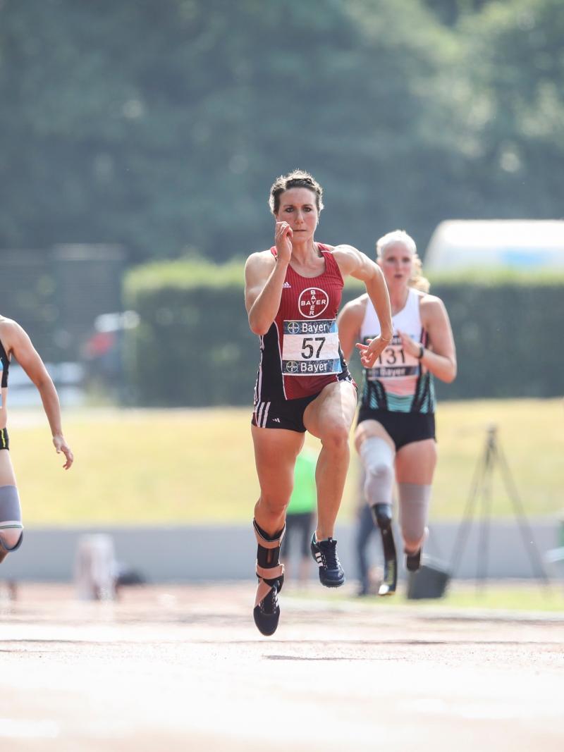 Four female Para athletes running in a track