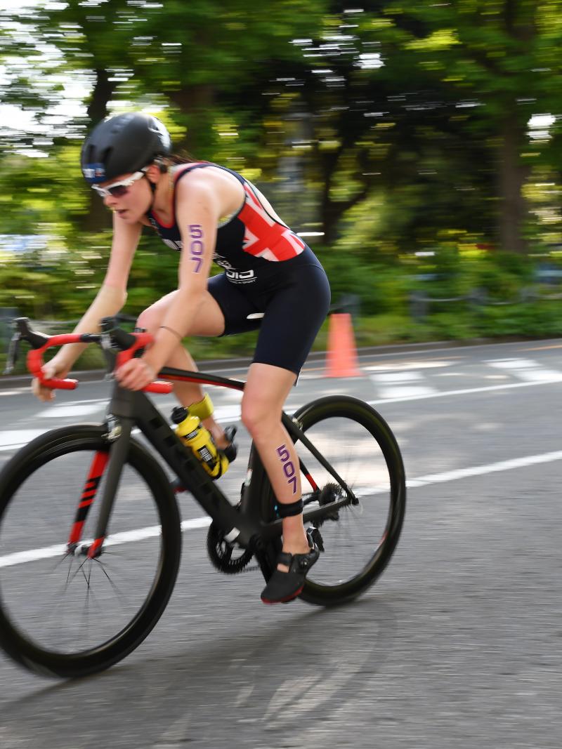Female British triathlete with arm impairment rides her bike