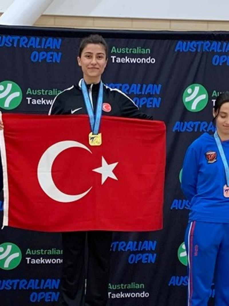 Woman taekwondo fighter on the podium holding the Turkey flag