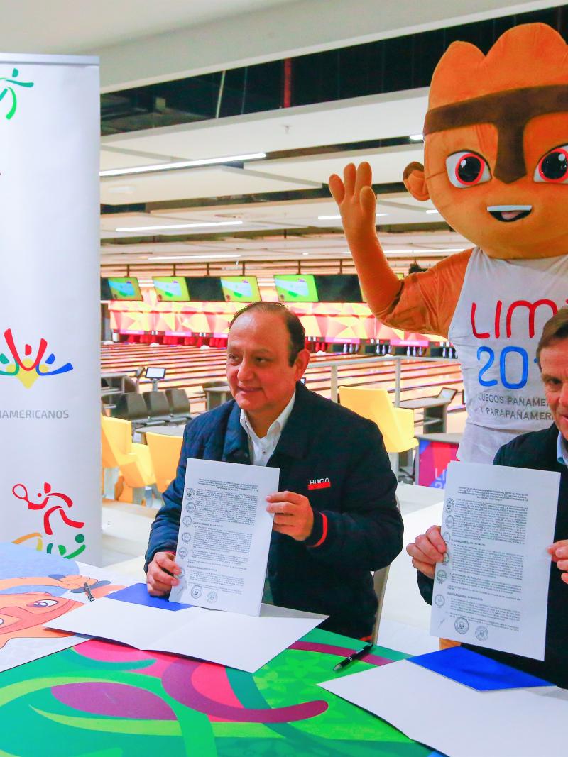 Lima 2019 President Carlos Neuhaus and Peruvian Ombudsman Walter Gutierrez holding the signed contracts