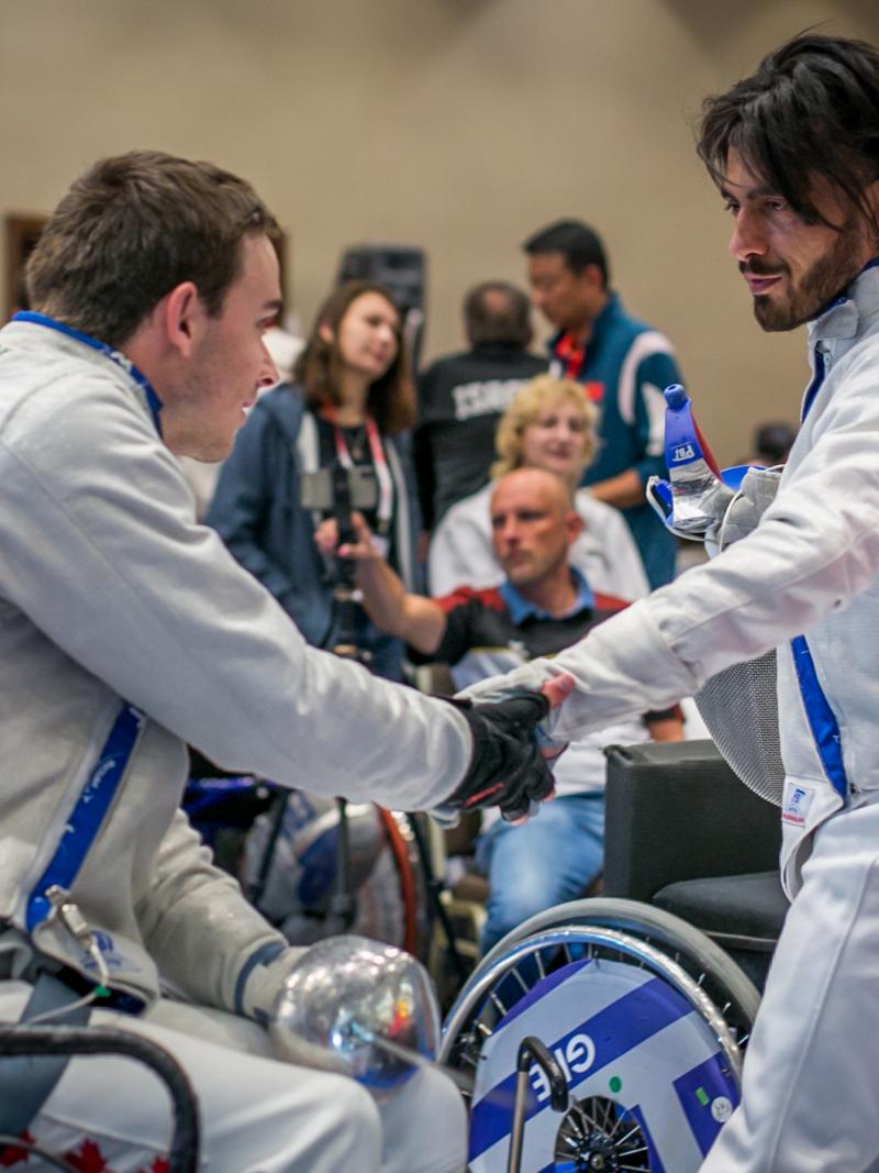 Iraq refugee Wissam Sami greets Canada's Ryan Roussel during the IWAS Wheelchair Fencing World Cup in Warsaw, Poland