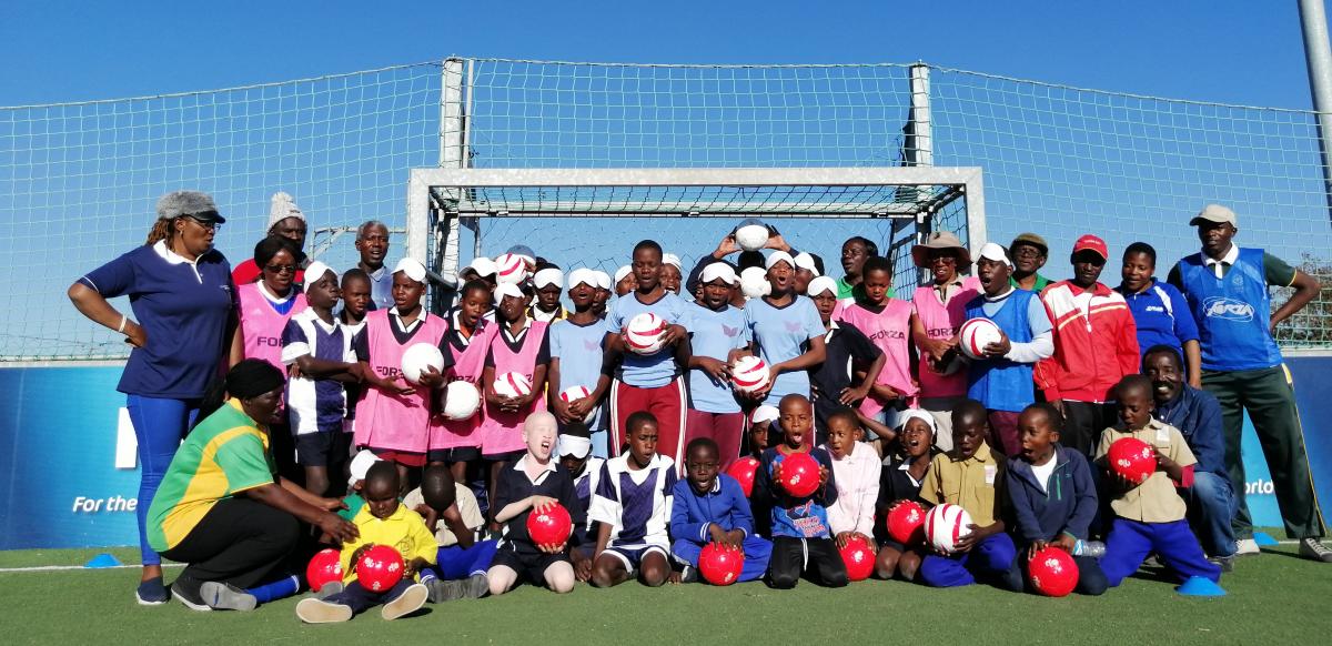 Kids pose for the photo in the blind football field