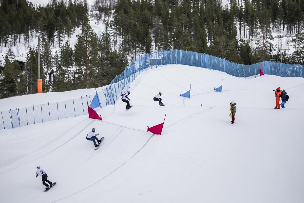 Four male snowboarders competing