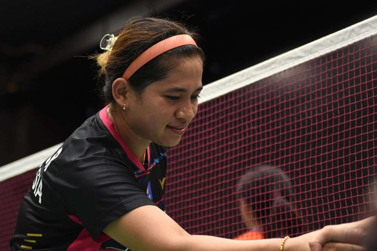 a female Para badminton player shakes hands with her opponent